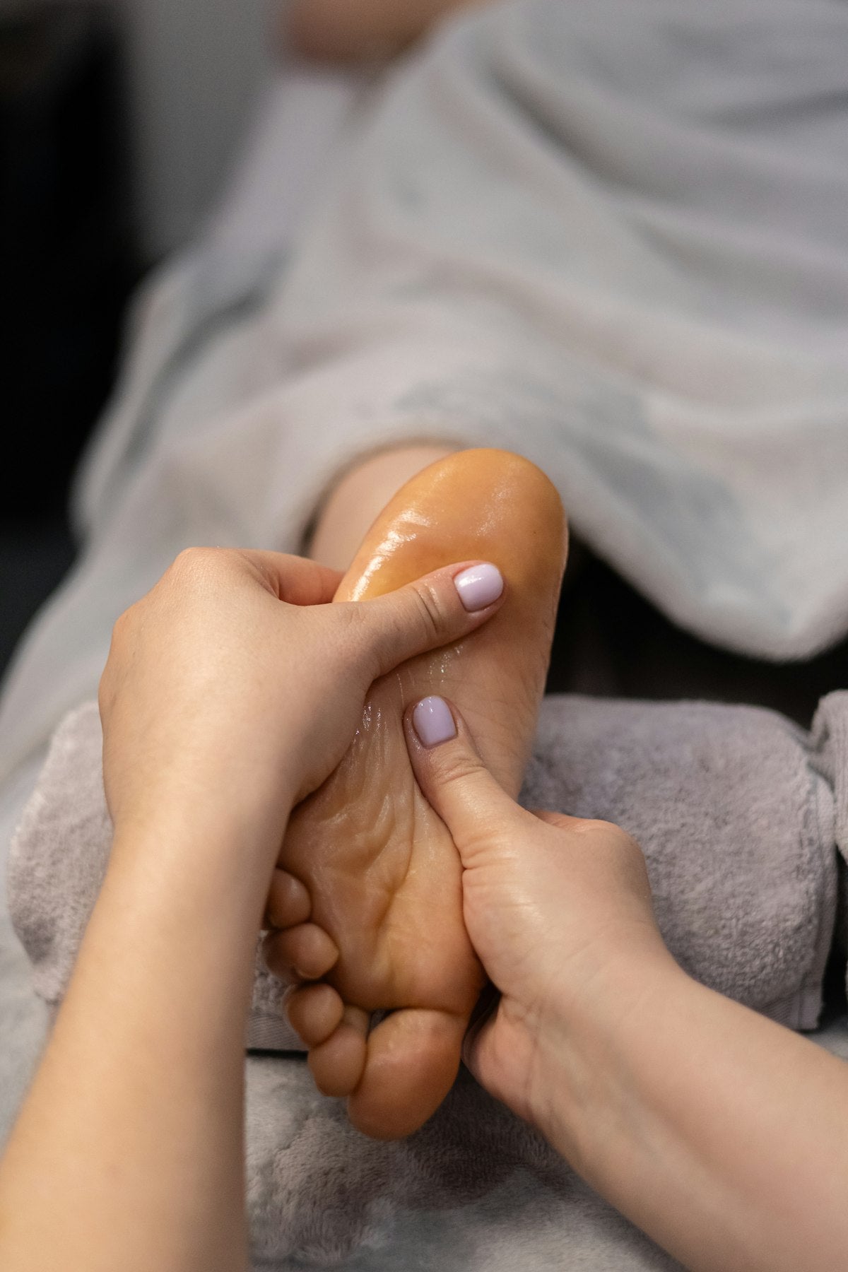 Woman using LamBac EMS foot massager for relief
